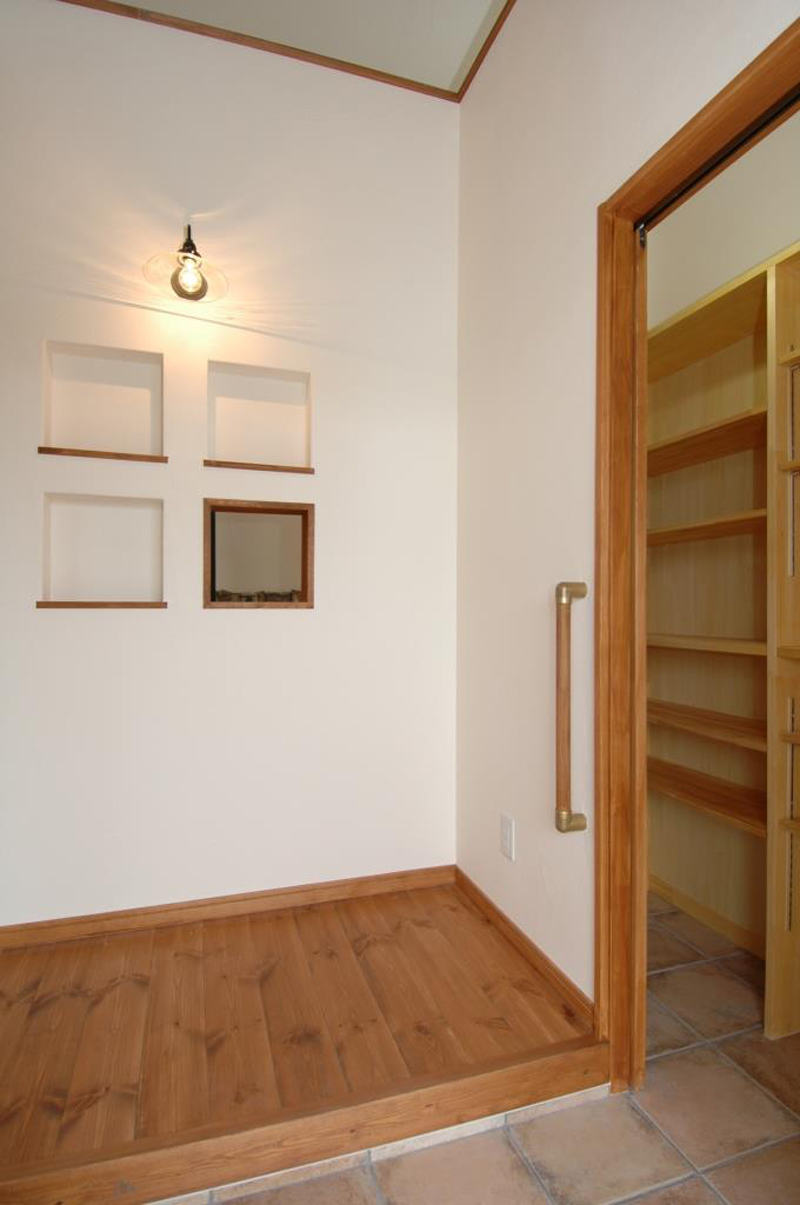 玄関の4つのニッチの右下は穴が開いており、玄関から薪ストーブが見える遊び心をプラス