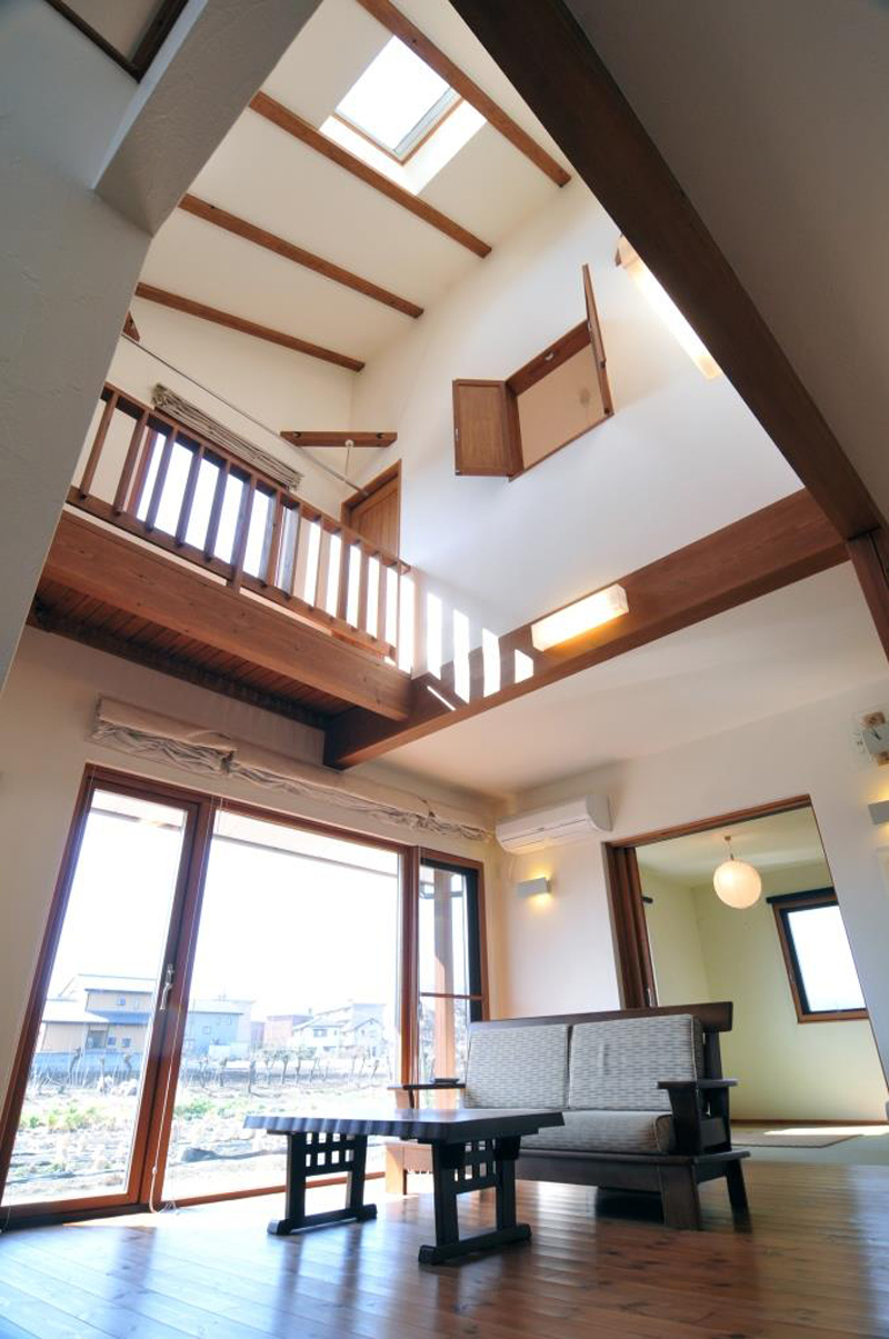 天窓から家中に光を集める開放的なリビング。パイン材と漆喰のコントラストが美しい。