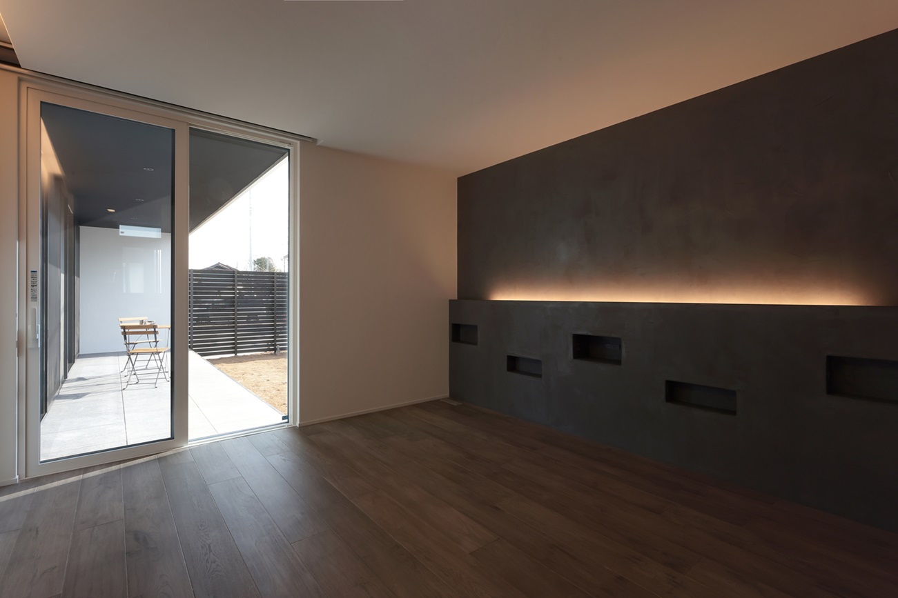 グレーの漆喰壁と間接照明で落ち着く寝室