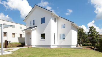 木々に囲まれた、自然と調和する漆喰の家